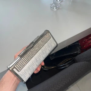 Neccessär dam - En riktigt fin neccessär till dam som funkar till olika tillfällen som exempel bröllop, fester men även vardagliga sysslor. Väskan är i silver med lite mönster på. Den är i bra skick och säljs billigt pågrund av ingen användning längre. Först till kvarn!