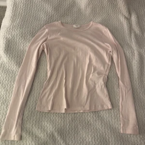 Ljusrosa långärmad topp Gina Tricot - Enkel och stilren ljusrosa långärmad topp från Gina Tricot, basically basics-kollektionen. Mjuk och stretchig i bomullsmix, rund halsringning och figurnära passform. Perfekt att matcha med jeans eller kjol för en clean look. Den är i storleken L men jag har M på tröjor och tycker den sitter helt perfekt!