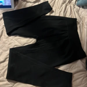 Svarta leggings från H&M Sport - Svarta leggings från H&M Sport med bred resår i midjan. De är stretchiga och sitter tight, perfekta för träning eller chill. Materialet är mjukt och följsamt, vilket gör dem riktigt bekväma att ha på sig.