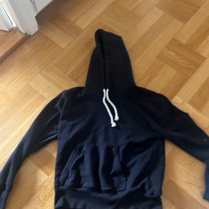 Acne hoodie svart med vit snörning - En stilren svart hoodie med vit snörning i huvan och en stor magficka framtill. Tröjan har långa ärmar och är tillverkad i mjuk bomull, perfekt för chill dagar. Klassisk passform och enkel design som funkar till det mesta. Sparsamt använd skicket är precis som ny priset går att diskutera