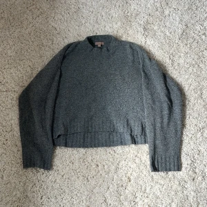 Grå stickad tröja från H&M - Mysig grå stickad tröja från H&M i storlek M. Tröjan har en enkel design med ribbade muddar vid ärmslut och nederkant samt en rak passform. Perfekt för lager-på-lager och chill dagar.