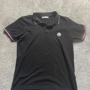 Moncler pike - Säljer en Svart Moncler piké sparsamt använd. Inga defekter. Storlek S men passar också XS