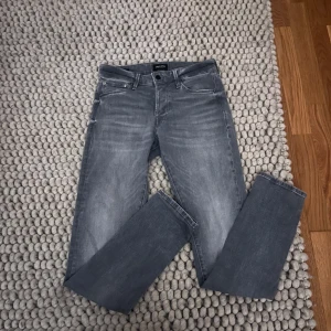 Grå jeans från Jack & Jones - Snygga grå jeans från Jack & Jones med klassisk femficksdesign och diskret tvättad look. Jeansen har raka ben och normal passform, tillverkade i mjukt jeanstyg som är sköna att bära hela dan men snabba affär sängs pris 