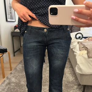Mörkblå jeansbyxor från River Island - Säljer ett par mörkblå lågmidjade bootcut jeans från River Island. Skitsnygga!! Vet inte riktigt storleken men skriv om ni vill ha mått