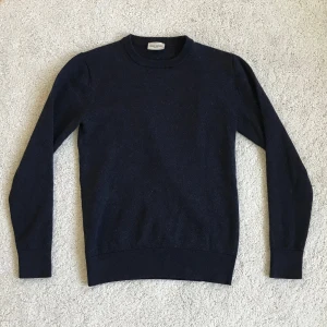 John Henric merinoull tröja  - Säljer en klassisk mörkblå tröja från John Henric i 100% merinoull. Det står att tröjan är S men den passar xxs-xs