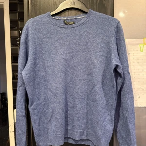 Blå kashmirtröja  - Säljer en mjuk och lyxig blå tröja i 100% kashmir från Massimo Dutti. Tröjan har rund halsringning och långa ärmar, perfekt för dig som vill ha något stilrent och bekvämt.  (Priset kan diskuteras vid snabb affär)