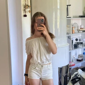 Vit offshoulder blus  -  söt vit offshoulder blus från Kappahl med resår vid halsringning och midja. Blusen har korta puffärmar och är tillverkad i ett lätt, luftigt tyg. Perfekt för varma dagar.