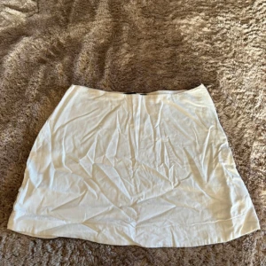 Vit kortkjol  - Säljer linne kortkjol från Bik Bok i storlek 34. Kjolen har en rak passform. Perfekt att matcha med en snygg topp eller hoodie.