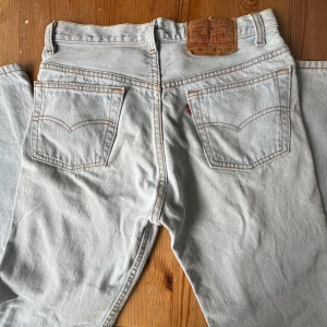 Levi's 501 ljusa jeans W29 L32 - Säljer ett par klassiska Levi's 501 jeans i ljusblå denim. Modellen har raka ben, fem fickor och den ikoniska läderpatchen bak i midjan. Toppenfina, superfint skick! Mycket litet använda. 