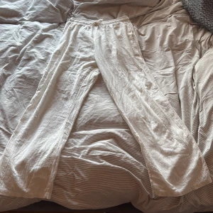 Vita linnebyxor  - Riktigt fina linnebyxor, köpt från bycastello. Ny pris: 395kr. Dem har en baggie passform och byxorna har en elastisk midja med knytband som ger flexibel passform. Litet hål på baksidan, men går o sy ihop, priset kan diskuteras pga det.