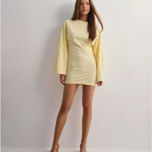 Ljusgul kortklänning med vida ärmar - Superfin ljusgul kortklänning med långa, vida ärmar och enkel rund halsringning. Oanvänd och perfekt till sommaren