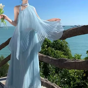 Set 2 delar Ljusblå  veckad maxi långklänning med oneshoulder plisserad - Säljer en drömmig ljusblå långklänning med plisserat tyg och oneshoulder-design. Klänningen har en elegant omlottkänsla och bred halsringning som knyts i nacken. Perfekt för sommarens speciella tillfällen.