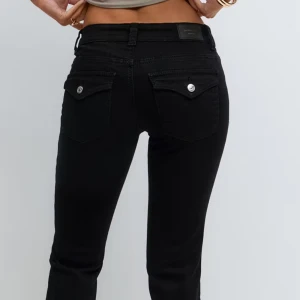 Svarta bootcut jeans från gina tricot stl XS - Snygga svarta jeans från Gina Tricot med bootcut passform och klassiska fem fickor. Jeansen har silverfärgade knappar och detaljer, samt ficklock med knapp på bakfickorna. Perfekta för dig som gillar stilrena och tidlösa jeans med en modern twist.De är för korta för någon som är lång mer än 165 cm så de passar de som har kortare längd än 165 cm.Nypris 499 kr.De finns på hemsidan.Använda en gång.
