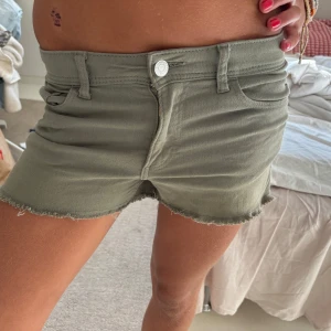 Gröna lågmidjade jeansshorts från H&M - Snygga gröna lågmidjade jeansshorts från H&M. Dom är i perfekt längd och så coola! Perfekta för hösten med strumpbyxor under. Storlek 164 men sitter som xs