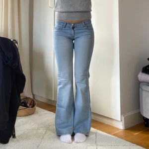 Bootcut ljusblå jeans - Säljer ett par lågmidjade bootcut jeans med broderade detaljer på bakfickorna. Midjemått: 36 cm, innerbenslängd: 80 cm💕jag är 166 för referens❤️skriv om ni har frågor!!