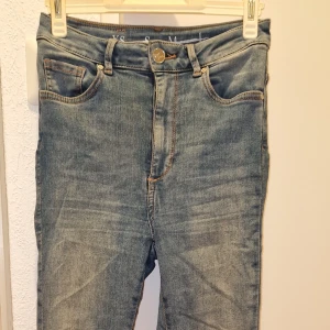 Blå jeans från Never Denim, skinny fit - Snygga blå jeans från Never Denim i skinny fit. Klassisk femficksmodell med ljus tvätt och bruna sömmar. Materialet är en mix av bomull, polyester och elastan för skön stretch. Perfekta för dig som gillar en tajt passform och stilren look.