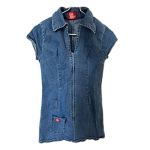 Jeansklänning från Miss Sixty - Cool vintage mini jeansklänning från Miss Sixty i klassisk blå denim. Modellen är kortärmad med krage, dragkedja framtill och coola fickdetaljer. Passar xxs!