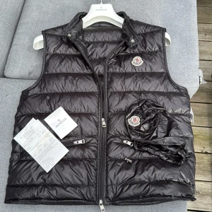 Moncler väst, storlek 3 - Tjena!! Säljer nu min feta moncler gui väst som jag köpte på NK i Göteborg, för den har inte kommit till användning och hänger bara i garderoben. Den är i nyskick, finns inga skador på västen. Har inte kvar tagsen för har slarvat bort de men har kvitto. Nypris runt 9500 kr i butik.  Hör av er vid minsta fundering 