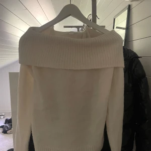 Offshoulder vit stickad tröja Gina Tricot - Endast använd 2 gånger! Superfin vit stickad tröja från Gina Tricot med bred offshoulder-krage. Tröjan har lång ärm och ribbade detaljer vid krage och muddar. Perfekt för dig som gillar en stilren och mysig look.