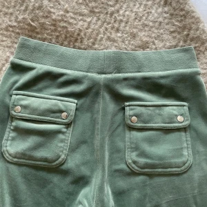 Juicy Couture byxor - Säljer nu mina gröna sköna mjukisbyxor från Juicy Couture då de inte längre kommer till användning. Fina i skicket, utom att en metallsak från bandet i midjan försvunnit i tvätten, se sista bild. 