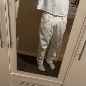 Vita jeans - Säljer ett par vita jeans med klassisk femficksdesign och rak passform. 