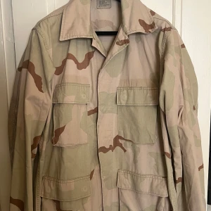 Field Jacket/ militärjacka - Camo Vintage Field Jacket i snygg ljus färg. Perfekt vintage-skick. Storlek M.