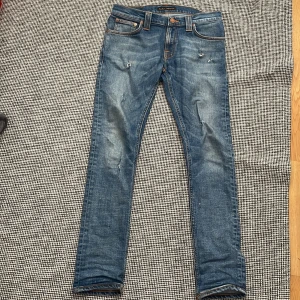 Blå slimfit  jeans från Nudie Jeans - Säljer ett par blå  från Nudie Jeans i storlek 28/30 Tillverkade i bomull med feta slitna detaljer, fett bra skick skulle säga 9,5/10 