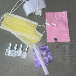 Depend Gellack nagelkit med UV-lampa - Nagelkit med fyra Depend Gellack-flaskor (top coat, base coat, två färger i ljusrosa och nude), vit UV-lampa, elektrisk nagelfil med olika sliphuvuden, tippar, nagelklämma och tillbehör. Perfekt för dig som vill fixa snygga gelnaglar hemma. Jag säljer 4 gellack av de depend där 2 av dom är base och top coat medans dom andra är jättefina neutrala färger som förstärker dina naglar, helt oöppnade. De ingår också en uv lampa från depend som funkar utmärkt. Säljer även en elfil i kitet. Ingår också l