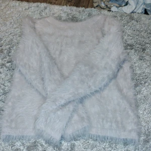 Ljus fluffig tröja från H&M - Supermjuk och fluffig ljusrosa tröja från H&M. Tröjan har lång ärm och är tillverkad i ett syntetmaterial som ger en mysig känsla. Perfekt för kyliga dagar när du vill vara både bekväm och snygg.