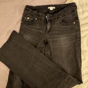 Svarta bootcut jeans från Gina Tricot - Snygga svarta jeans från Gina Tricot med bootcut passform. Jeansen har bakfickor med lock och knapp.