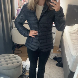 marinblå jacka från Moncler - Säljer en marinblå dunjacka från Moncler med klassisk design och knappar framtill. Jackan har Moncler-logga på armen.