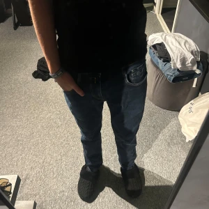 Replay Anbass jeans mörkblå - Säljer ett par snygga Replay Anbass jeans i mörkblå tvätt med klassiska fem fickor och gul kontrastsöm. Jeansen har en slim passform och är tillverkade i mjukt jeansmaterial med lite stretch för extra komfort. Strl 30/32