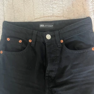 Svarta raka jeans från Zara - Snygga svarta jeans från Zara med raka ben och mid/låg midja i 100% bomull. Knappt använda.