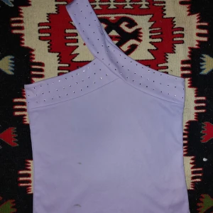 Ljuslila oneshoulder topp med nitar - Charmig oneshoulder topp i ljuslila med silvernitar 