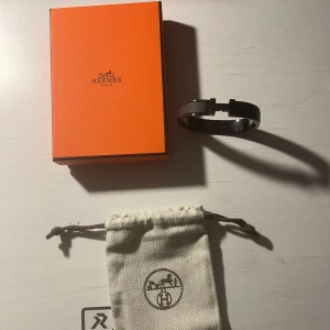 Herms Armband - Säljer nu mitt armband då jag inte använder det längre. Finns inga repor vad jag kan se eller liknande. De är gjort i metall och är väldigt stilrent till vardagen! Du får med original box och en liten dustbag till. Hör av dig vid fler funderingar.