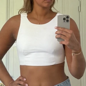 Vit topp öppen rygg - Säljer en vit croppad linnetopp med breda rynkade axelband och öppen rygg. Från Zara