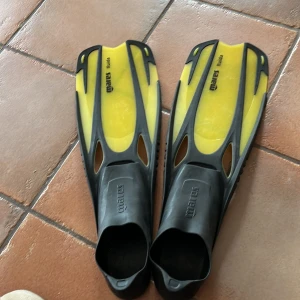 Gula och svarta simfenor från Mares - Säljer ett par gula och svarta simfenor från Mares. De har en sluten häl och är tillverkade i syntetmaterial. Perfekta för simning och snorkling. Storlek EU 38-39.