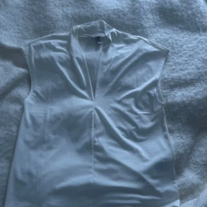 Vit ärmlös blus från H&M - Säljer nu min vita blus ifrån hm. Den är v ringad och har inga hål eller andra effekter säljer pga att den inte kommer till användning längre. För mer frågor eller bilder kom privat 