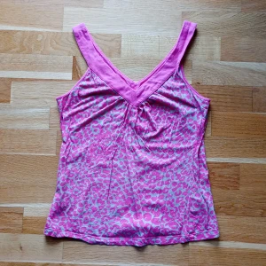 Rosa leopardmönstrat linne från Twilfit - Säljer en rosa linnetopp från Twilfit med leopardmönster. Toppen har breda axelband och en v-ringad halsringning🩷