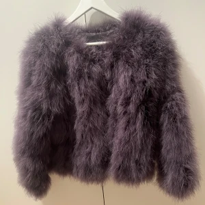 Grå pälsjacka WOS - Fluffig och trendig grå pälsjacka med rund halsringning och lång ärm. Jackan har en lyxig känsla och passar perfekt när du vill sticka ut med din outfit. Snygg att styla till både jeans och klänning. Som nytt skick!