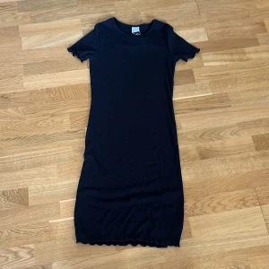 Svart kortärmad ribbad klänning - Säljer en svart kortärmat miniklänning från Ginatricot i storlek S, endast använd en gång. 50kr plus frakt, välj gärna instabox om möjligt