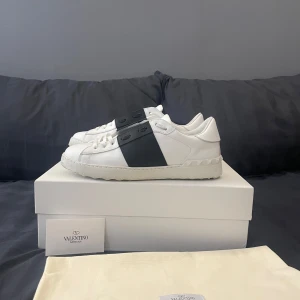 Valentino Open sneakers - Säljer nu dessa svartvita Valentino opens. | Dom är i riktigt fint skick för att vara använda då dom endast är använda cirka 5-7 gånger. Skicket är 8/10 skulle jag säga. | Det som ingår är skolandan, en dustbag, ett Valentino kort som ligger i ett Valentino kuvert och så klart skorna. | Det är bar att höra av sig om man har några frågor eller vill ha fler bilder.