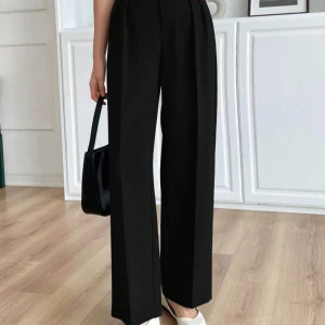 Svarta kostymbyxor  - Säljer ett par svarta kostymbyxor från Shein  i storlek XS. Byxorna har hög midja, vida ben och stängs med dragkedja och knapp. Perfekta för en stilren och trendig look. Sitter jättefint på kroppen. Ej använd bara provats en gång. 