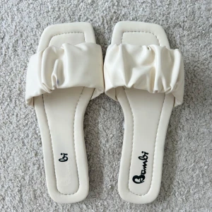 Slip-ins - Säljer ett par jättefina  sandaler från Bambi med bred rynkad rem över foten. Perfekta till sommaren! Har en liten fläck (se andra bilden), men inget man tänker på🤍