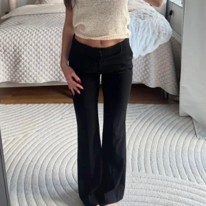 Svarta kostymbyxor - Säljer ett par svarta kostymbyxor. Byxorna har klassisk design med dragkedja och knäppning framtill. Perfekta för en stilren look och passar till många olika outfits, jag är 163cm och på mig går de precis till marken🥰