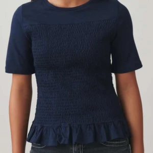 Mörkblå topp med volang - Mörkblå topp från gina tricot. Storlek 170 men passar s/m. använd 2/3 gånger