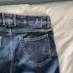 Mörkblå jeans från Jacob Cohen - Snygga mörkblå jeans från Jacob Cohen med klassiska kontrastsömmar och femficksdesign. W34. Modell: 622 comfort