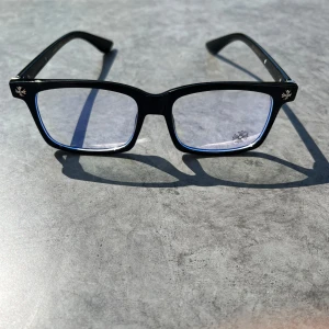 Chrome hearts glass ögon helt nya  - Stilrena svarta glasögon med rektangulära bågar i blank plast. Klassisk design som passar till många olika stilar. Bågarna har en diskret detalj på skalmen.