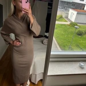 Beige långklänning med omlott och lång ärm - Säljer en beige långklänning med omlott-effekt och långa ärmar. Klänningen har en figurnära passform och är perfekt för dig som gillar en stilren och enkel look. Materialet känns mjukt och bekvämt mot huden. Aldrig använd 
