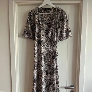 Omlottklänning från Soaked in Luxury - Säljer min mammas fina klänning🌸Fint mönster. Man kan knyta åt den i midjan för en fin figur🤩 Lätt material som är perfekt nu inför sommaren. Skriv om ni vill ha bilder🌸Pris kan diskuteras!🤩